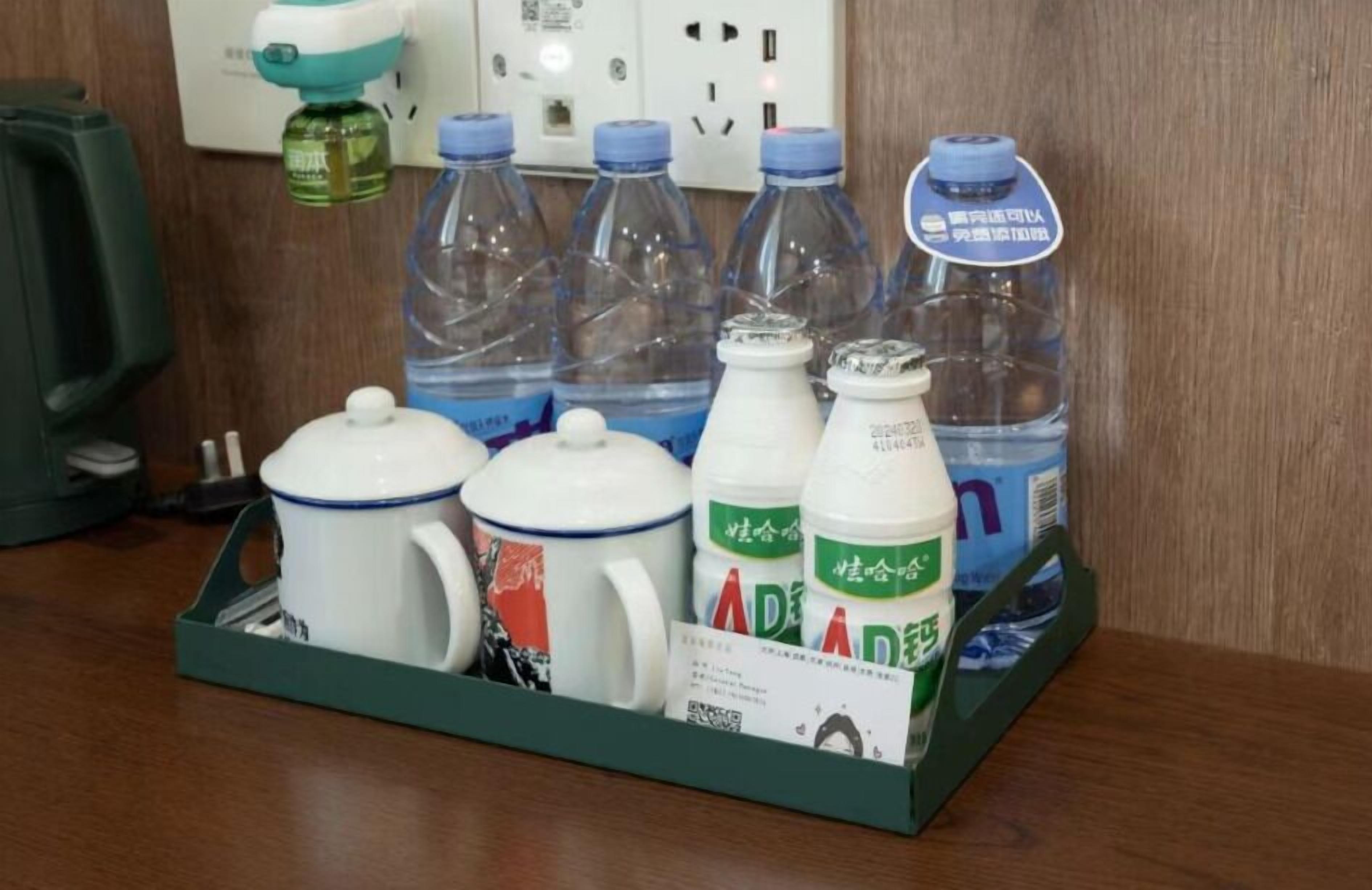 Una bandeja con diversos objetos, incluyendo botellas, una taza y una caja con la etiqueta 'AD'.