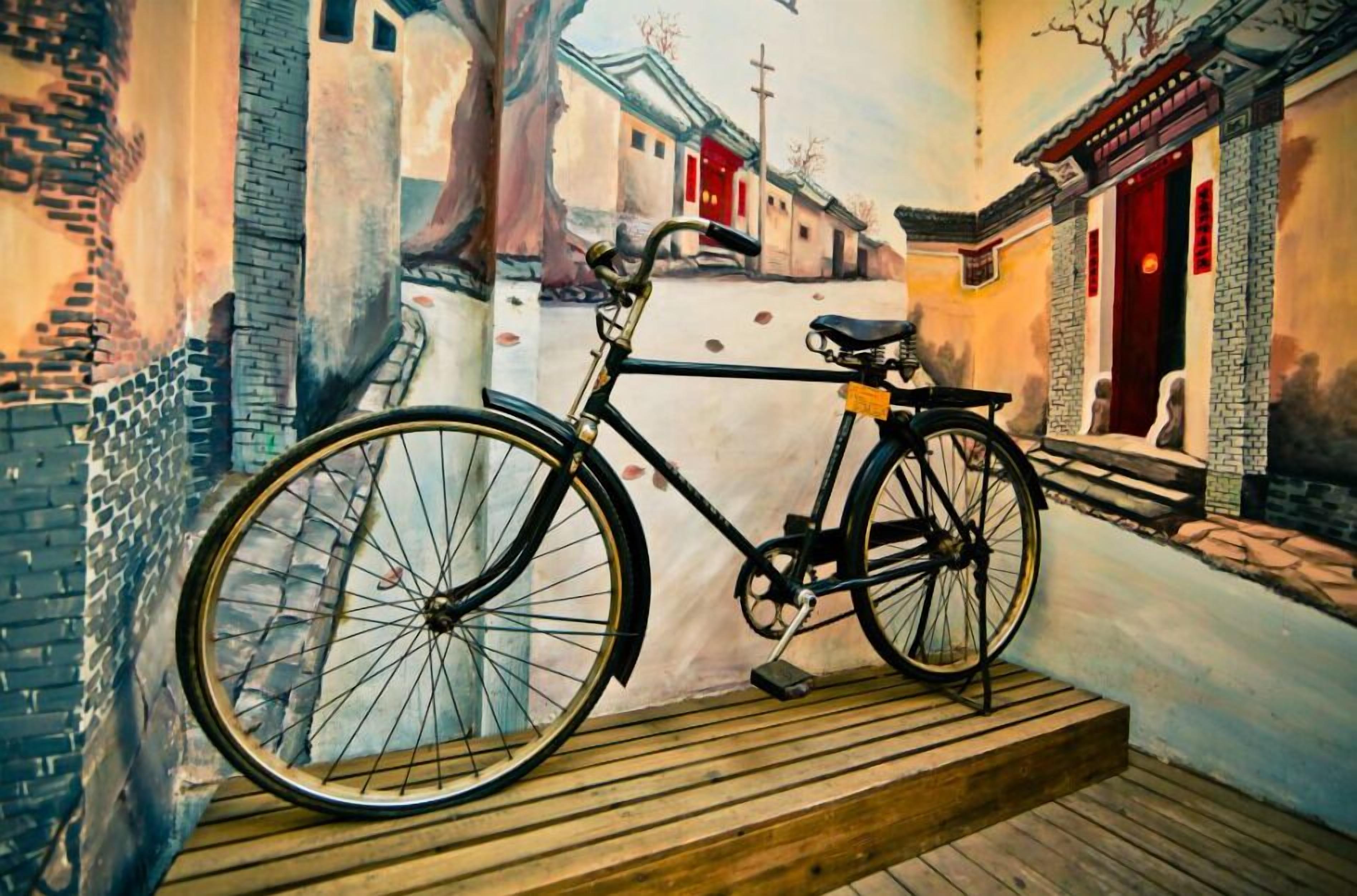 A bicycle parked on a wooden platform in a narrow alleyway with traditional buildings on either side.