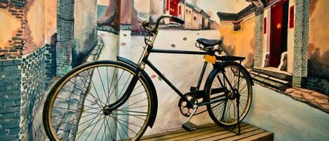 A bicycle parked on a wooden platform in a narrow alleyway with traditional buildings on either side.
