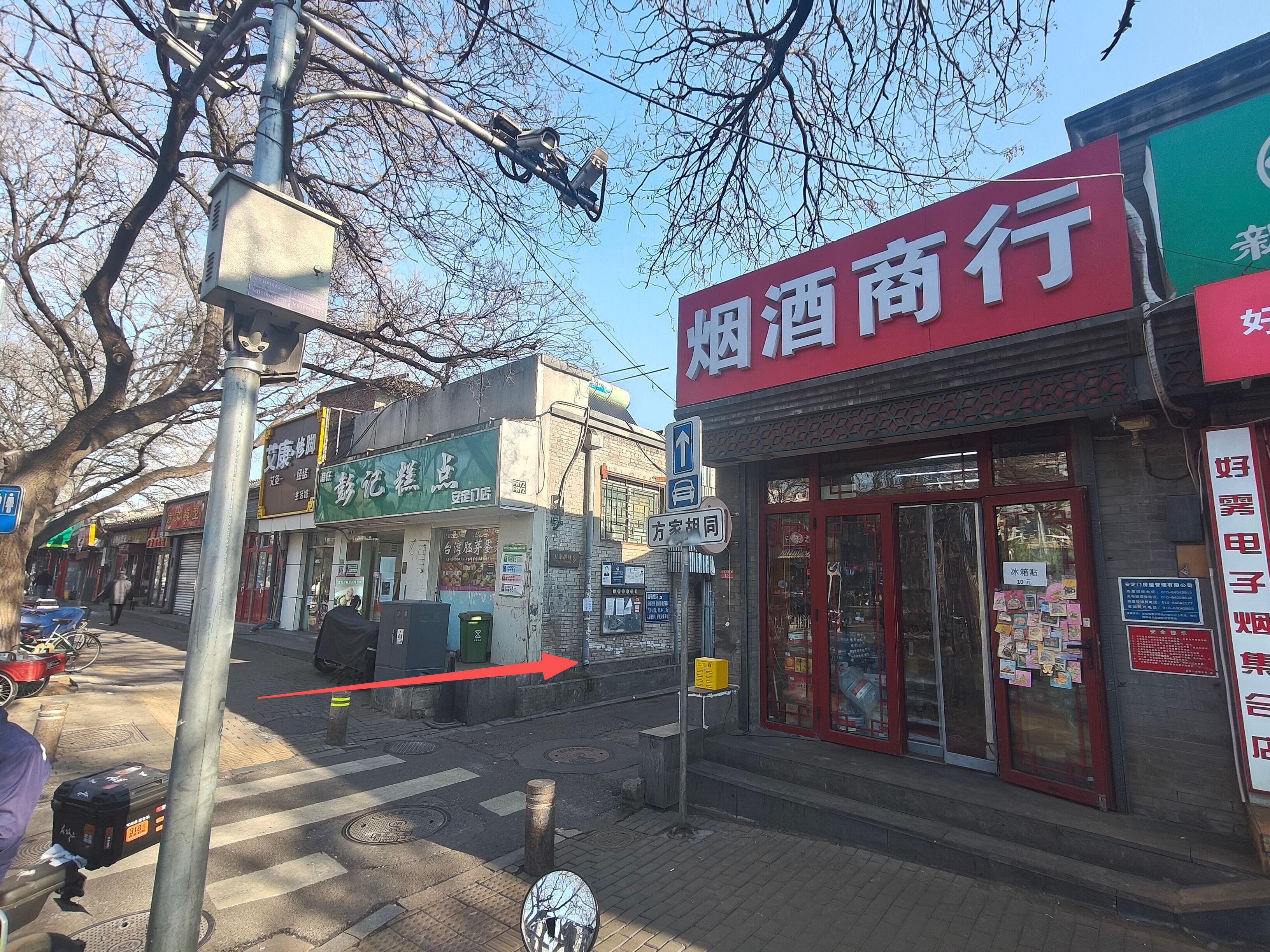 A street view with a storefront labeled "烟酒商行" and another with a green sign.