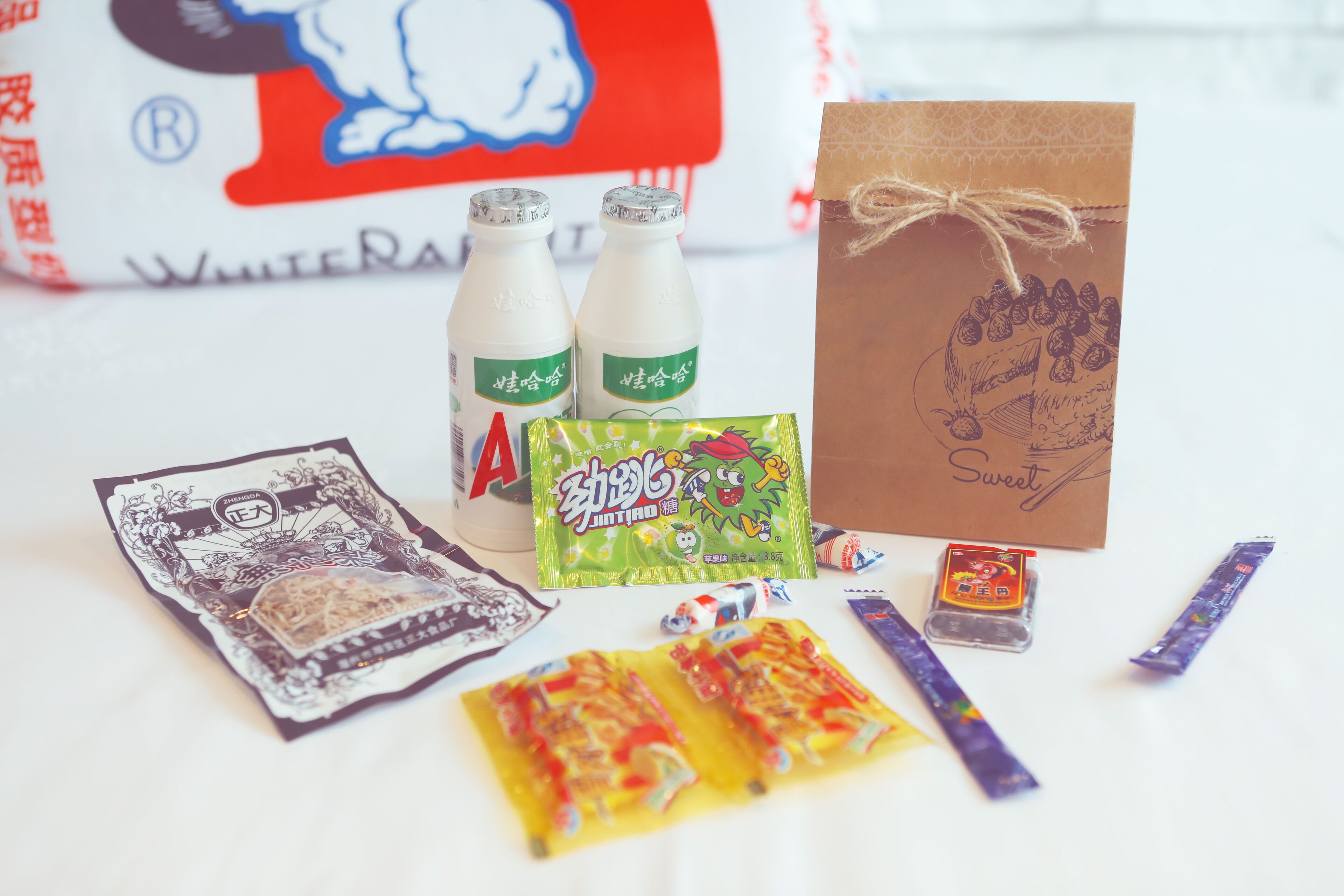 A table with various food items, including packaged snacks and bottled beverages.