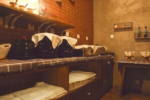 A compact kitchen with a brick wall, wooden cabinets, and a small table with a cloth. - Nostalgia Hotel（Beijing Yonghe Lama Temple） (Beijing)