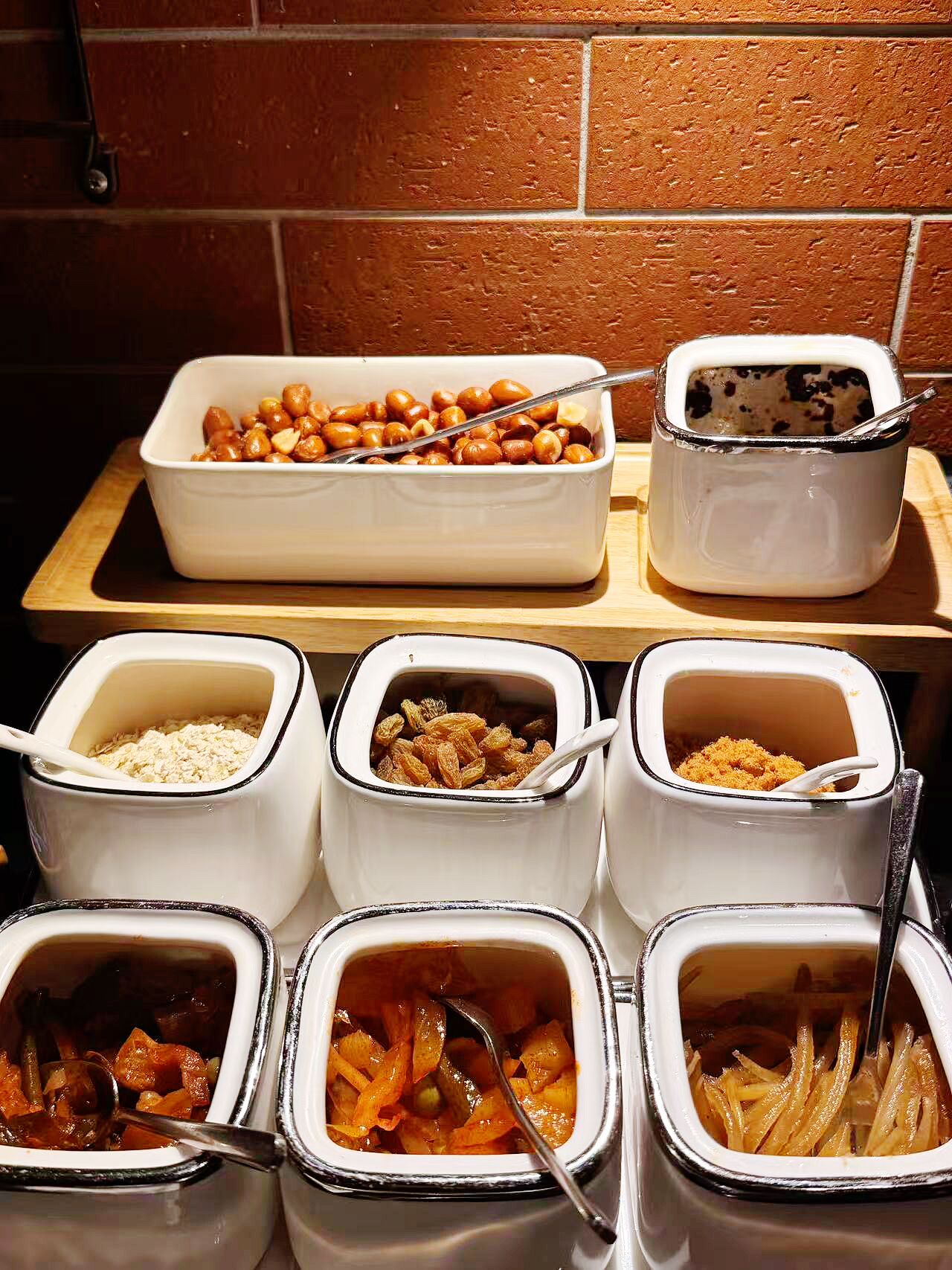 A buffet with various food items including nuts, cereal, and vegetables.