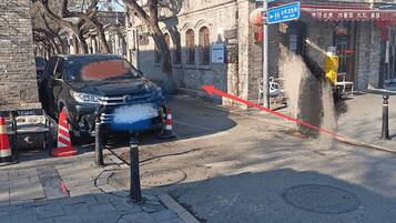 Katukuva, jossa näkyy pysäköity auto tien varressa, pysäköintikielto-opaste ja rakennus, jonka kyltissä lukee: ”Fanchang-katu”.