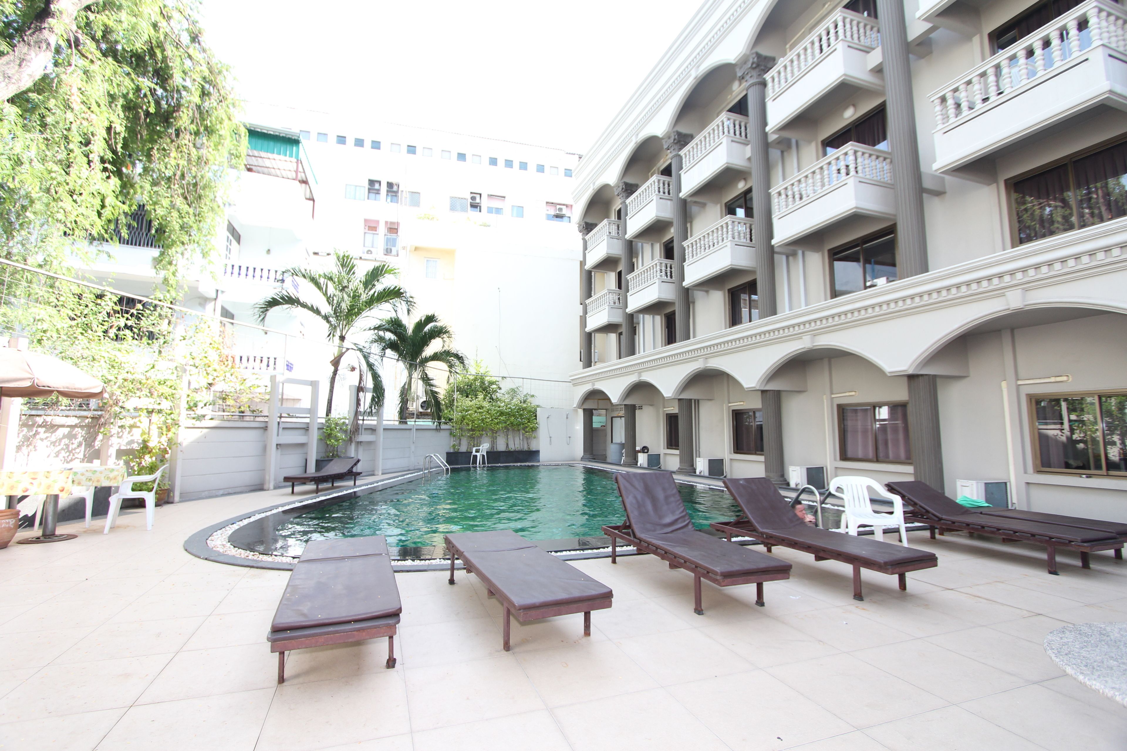 A pool area with lounge chairs and a small pool.