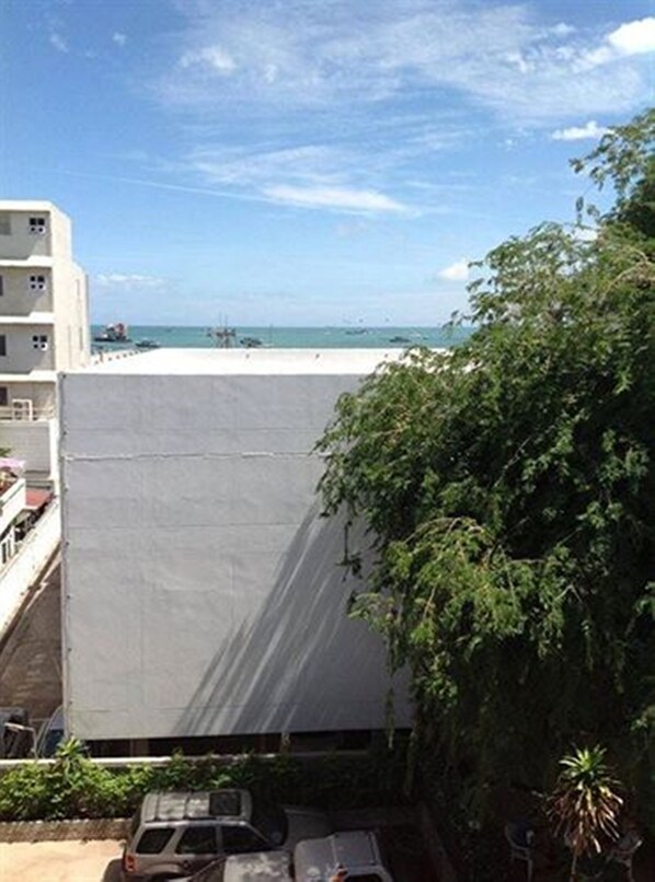 A building with a flat roof, a covered area, and a view of the sea.