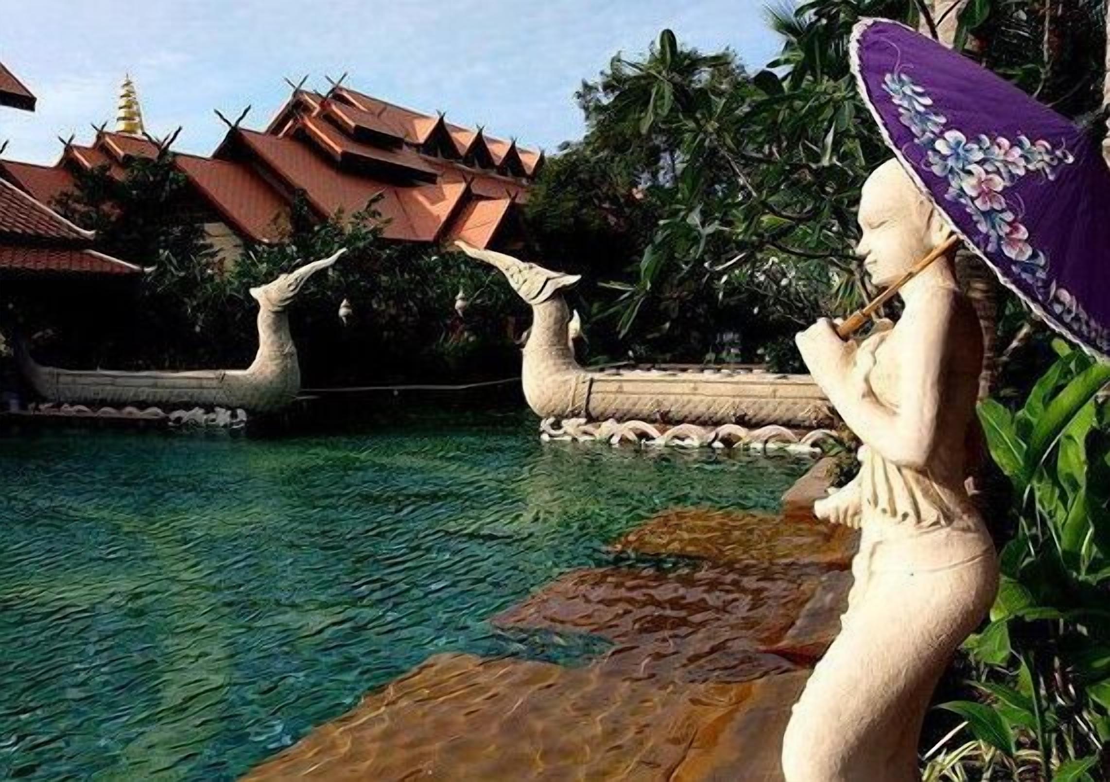 Une statue d’une femme tenant un parasol, près d’une piscine, avec une architecture traditionnelle en arrière-plan.