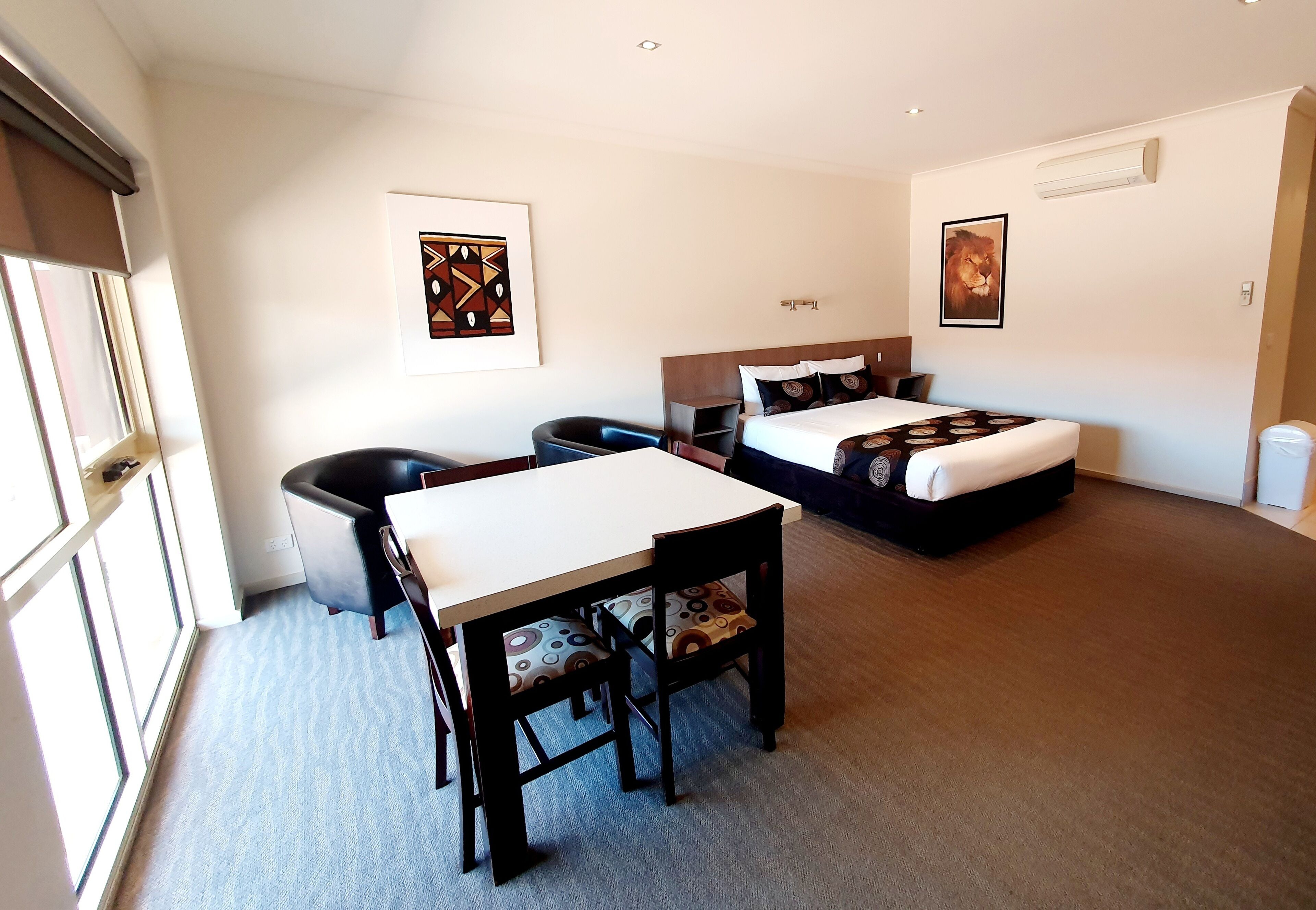 Een hotelkamer met een bed, een bureau en een stoel.