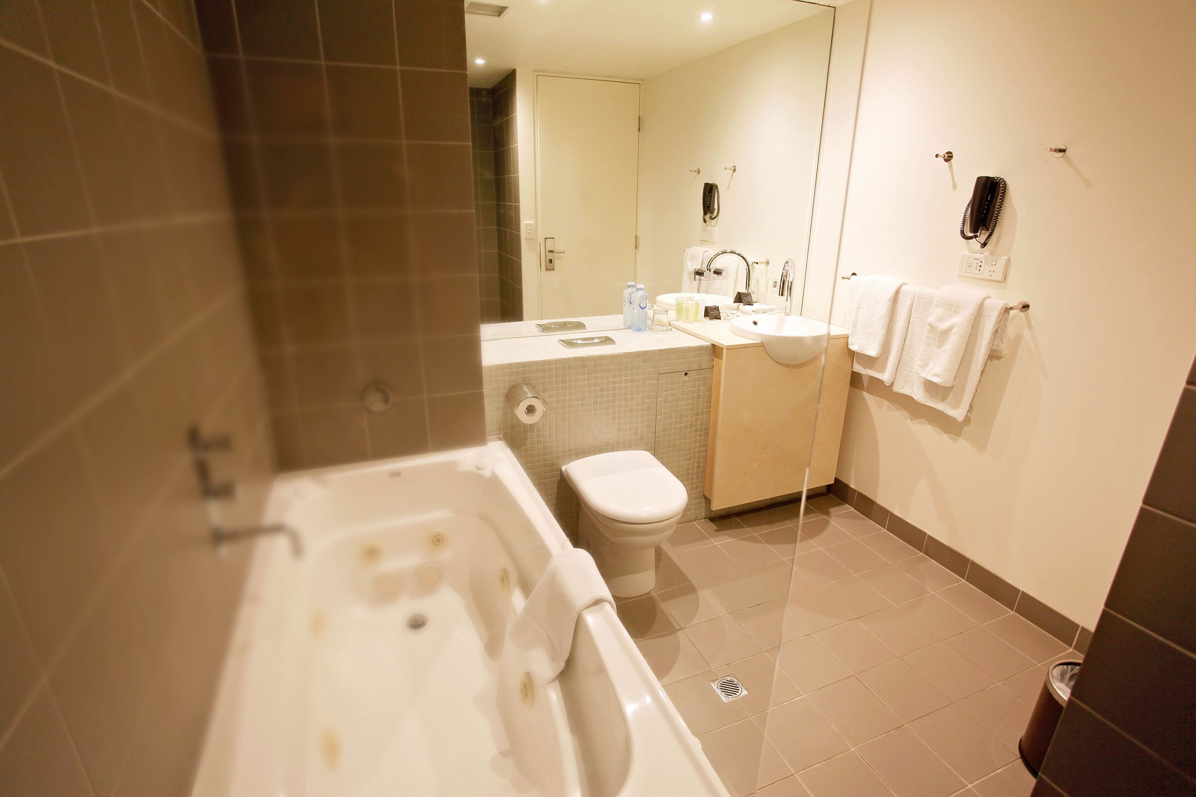 Un baño moderno con bañera, inodoro, lavabo y espejo.