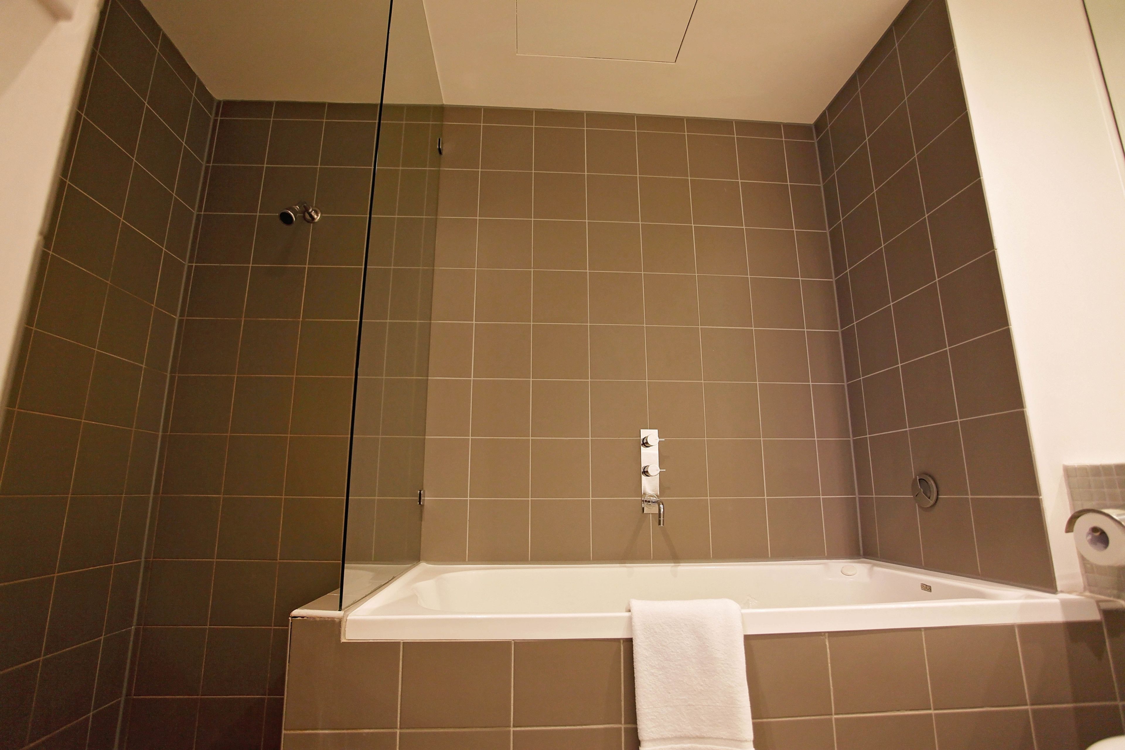 A bathroom with a bathtub, a shower area, and a toilet.
