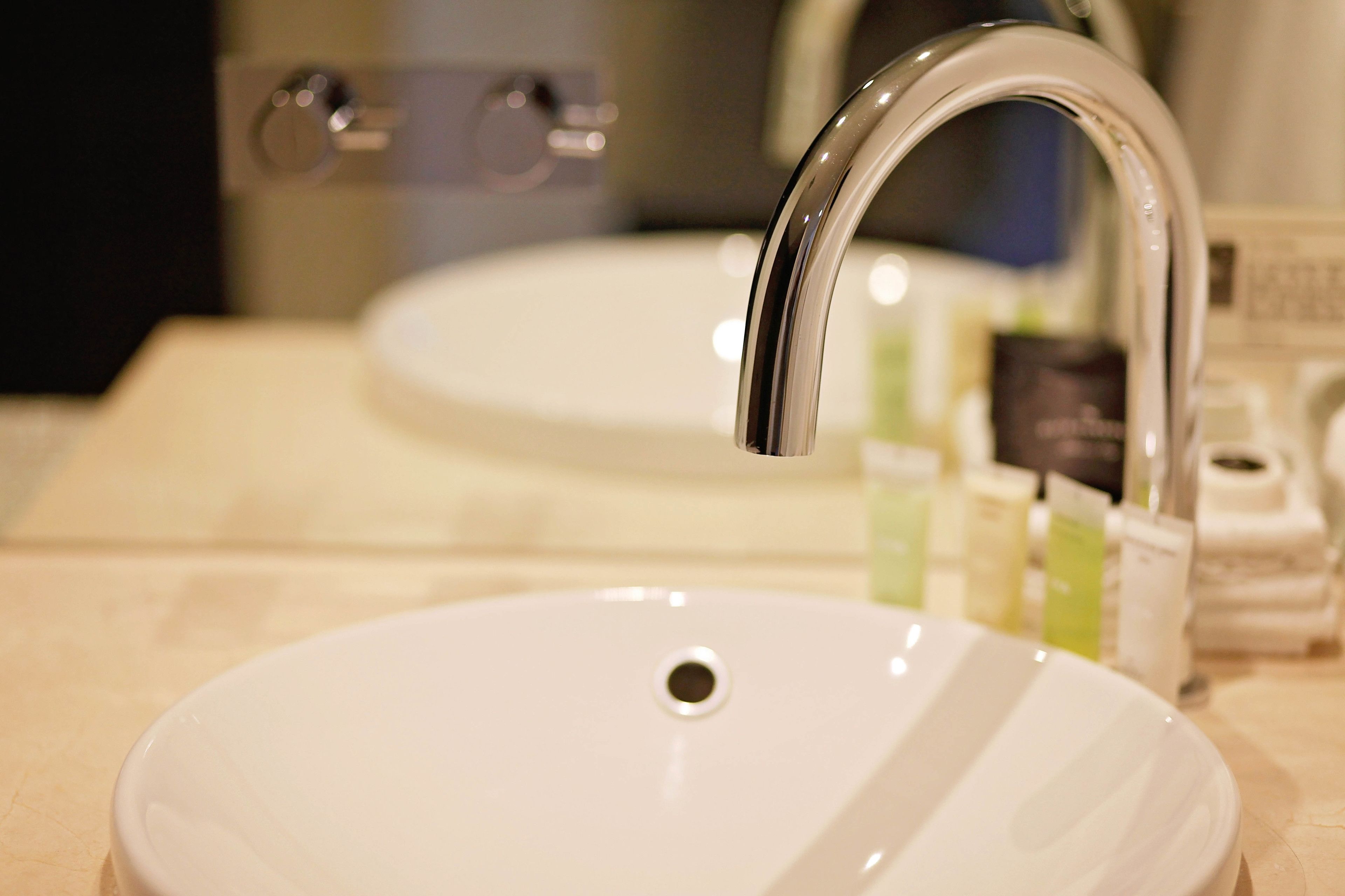 A bathroom sink with a chrome faucet and a mirror above it.