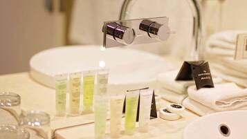 A bathroom with a sink, mirror, and various toiletries.