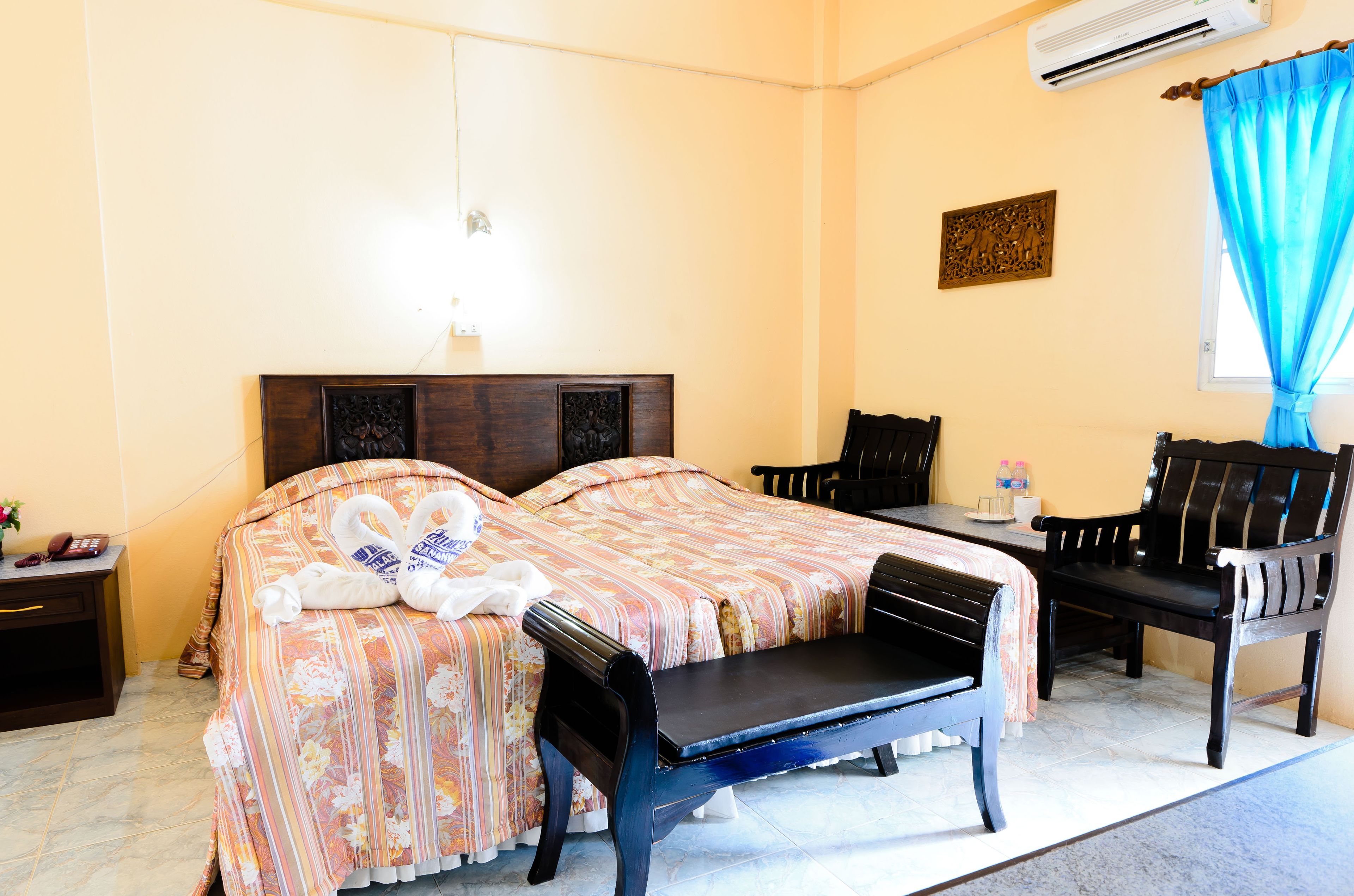 Een hotelkamer met twee bedden, een bank, een tafel en stoelen.
