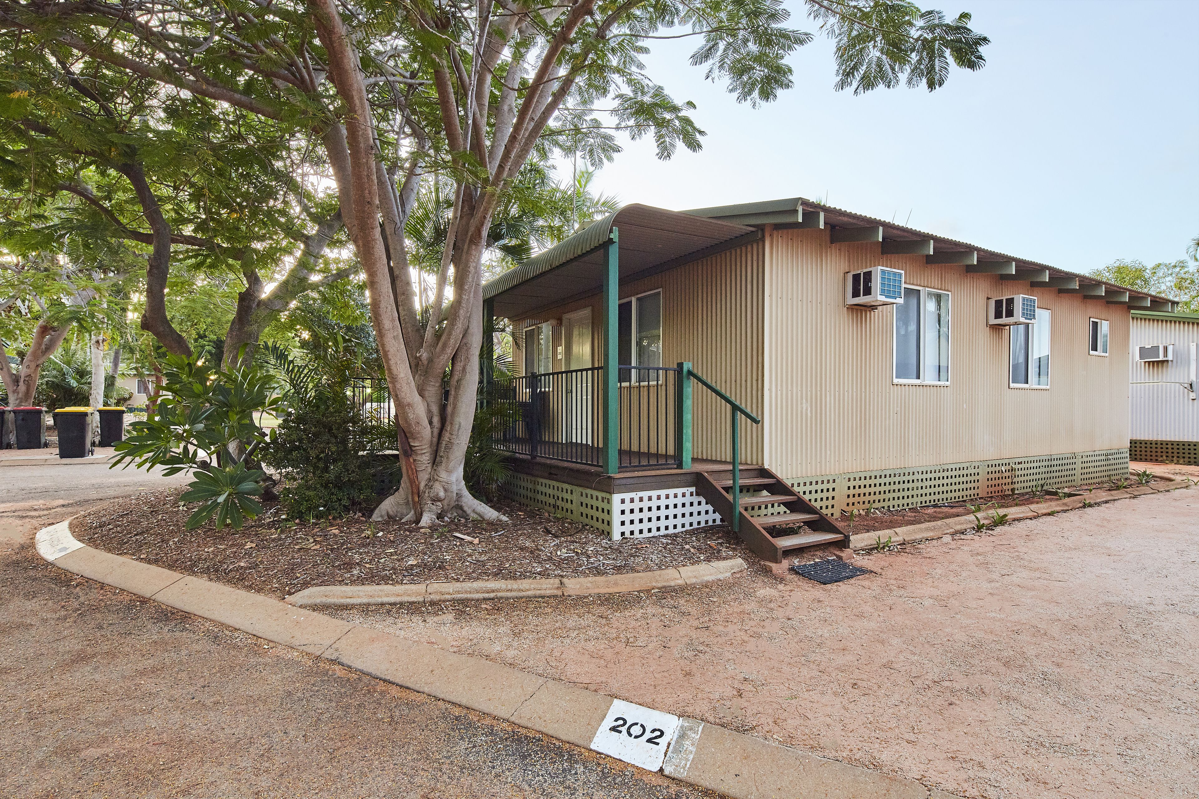 A single-story building with a covered porch and a small staircase leading to the entrance.