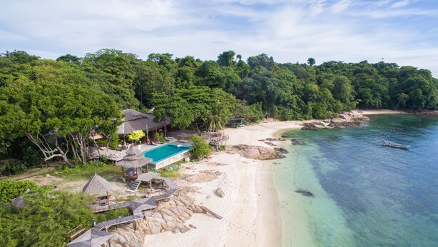 A beach resort with a swimming pool, thatched-roof structures, and a clear view of the ocean. - Koh Munnork Private Island (Koh Mun Nork)