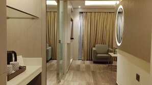 A hotel room with a bathroom, a seating area, and a mirror. - Fortune Murali Park, Vijayawada - Member ITC Hotels' Group (Vijayawada)