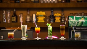 Un bar con diversas bebidas y botellas al fondo.