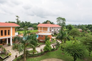 Un barrio residencial con casas, piscina y abundante vegetación.