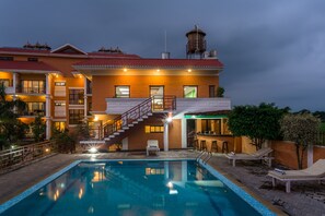 A hotel with a swimming pool, outdoor bar, and multiple balconies. - Landmark Forest Park (Sauraha)