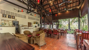 A restaurant with a high ceiling, exposed beams, and a terrace with outdoor seating. - SiZen Retreat & Spa (Siem Reap)