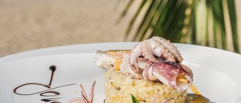 Un plato de comida con tentáculos de pulpo, arroz y guarniciones.