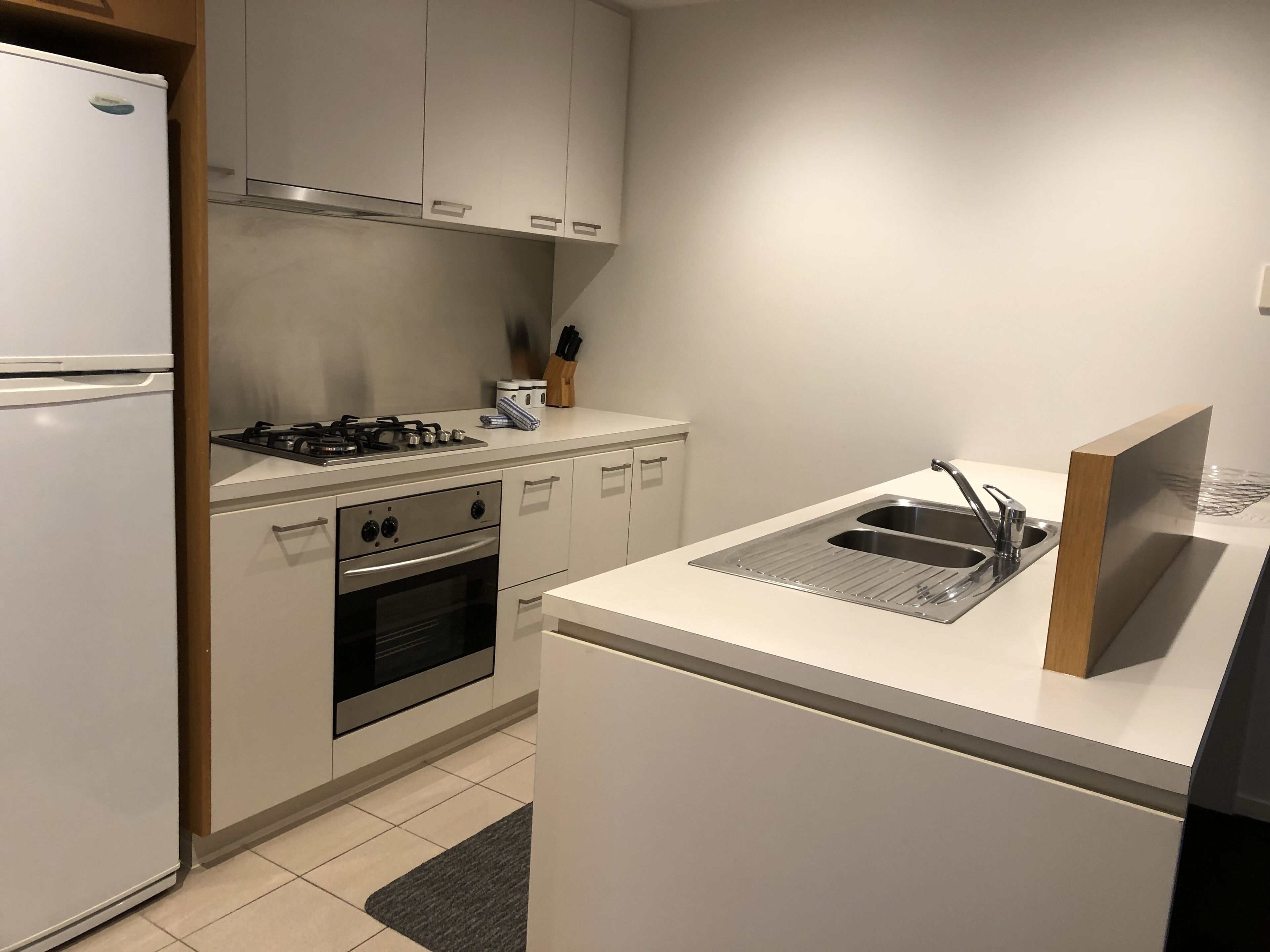 A modern kitchen with a refrigerator, stove, oven, and sink.