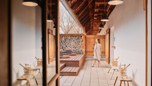 Un intérieur de style japonais traditionnel, avec un sol recouvert de tatamis, des poutres en bois et un mur en pierre.
