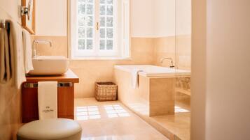 A modern bathroom with a large window, a sink, and a toilet.
