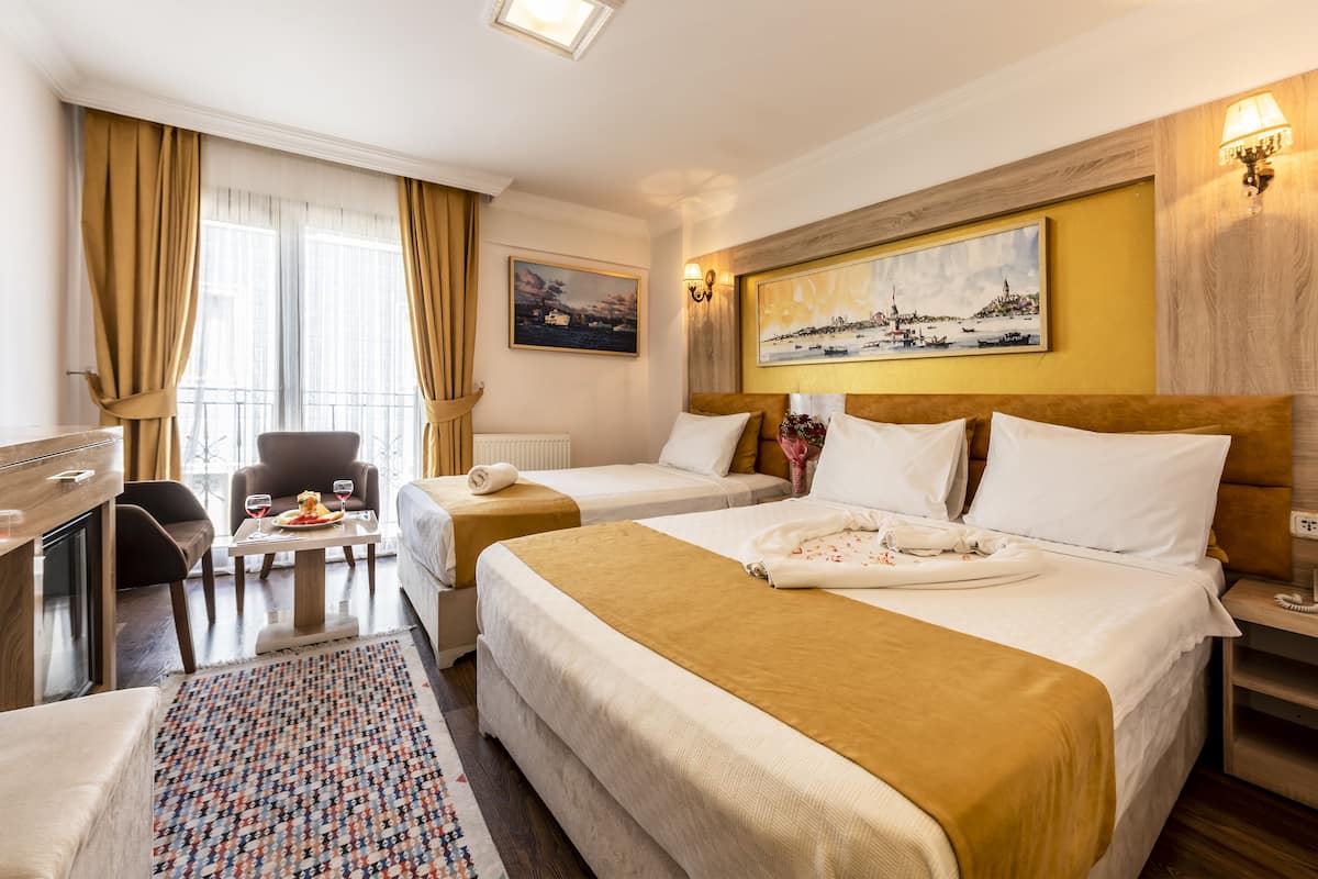 Deluxe driepersoonskamer | Luxe beddengoed, een kluis op de kamer, een bureau, een laptopwerkplek