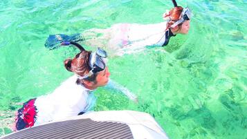 Zwei Personen schnorcheln in klarem Wasser.