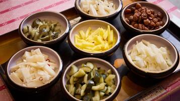 A tray with bowls containing various pickled vegetables and fruits.