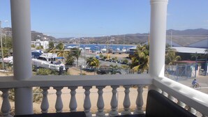 A balcony with white balustrades overlooking a marina with boats and palm trees. - HOTEL & CASINO ATLANTIC CITY de SAN JUAN DEL SUR (San Juan del Sur)