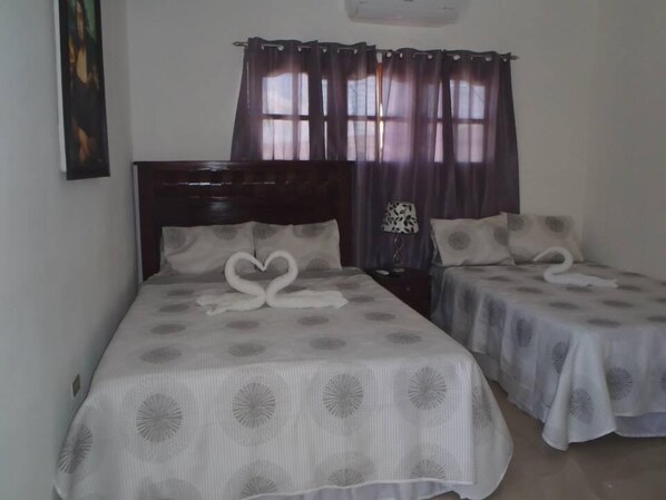 Une chambre d’hôtel avec deux lits, chacun agrémenté d’une décoration en forme de cœur réalisée avec des serviettes.
