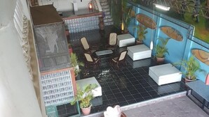 A spacious indoor area with a tiled floor, wooden furniture, and a mural on the wall. - HOTEL & CASINO ATLANTIC CITY de SAN JUAN DEL SUR (San Juan del Sur)