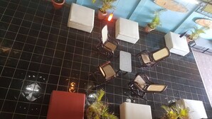 A tiled floor with several chairs and tables, potted plants, and a red bench. - HOTEL & CASINO ATLANTIC CITY de SAN JUAN DEL SUR (San Juan del Sur)