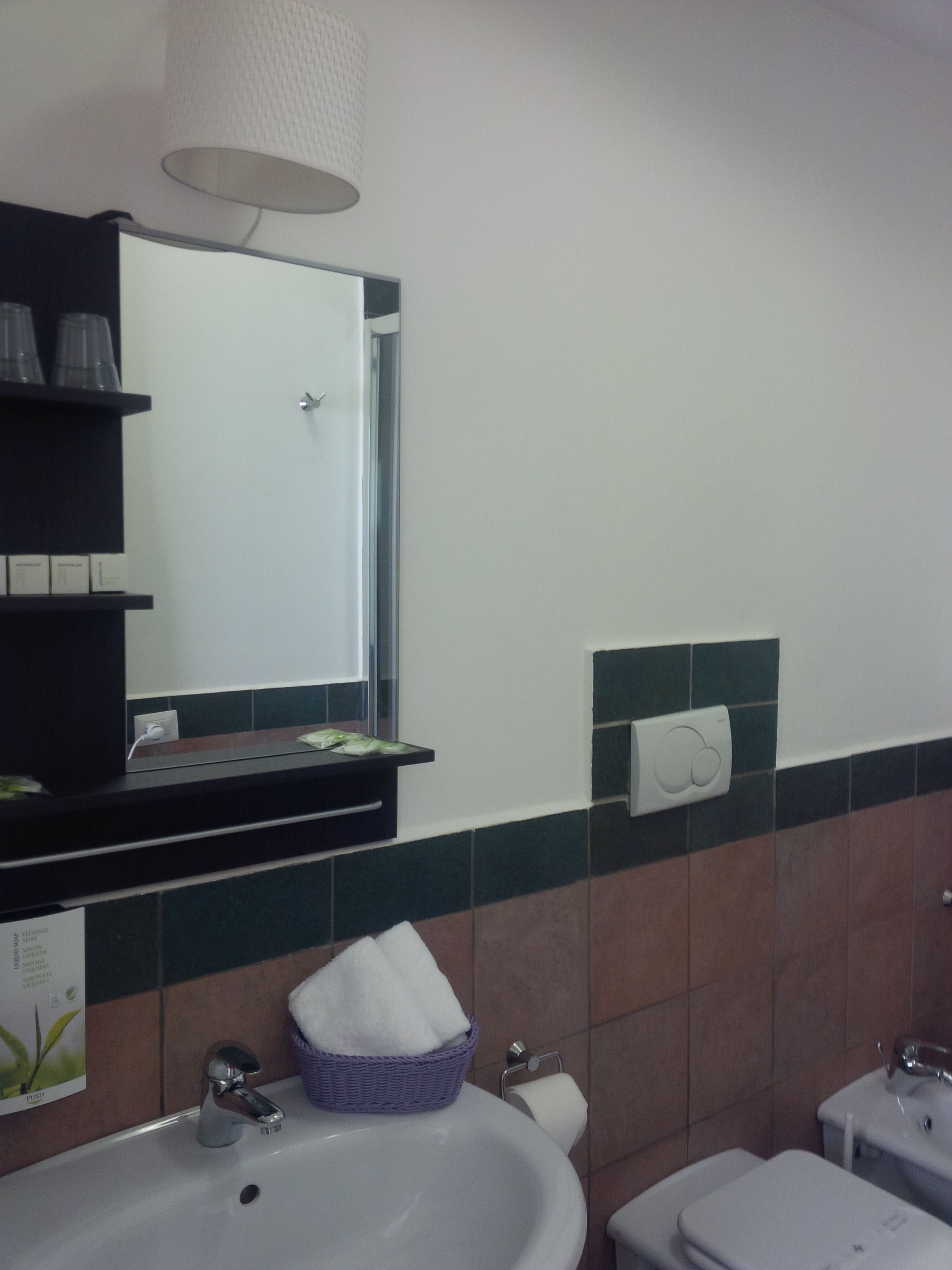 A bathroom with a sink, mirror, towel rack, and toilet.