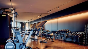 A gym with exercise equipment, weight racks, and a polished wooden floor. - TAUROA Schönberghof Spielberg (Spielberg)