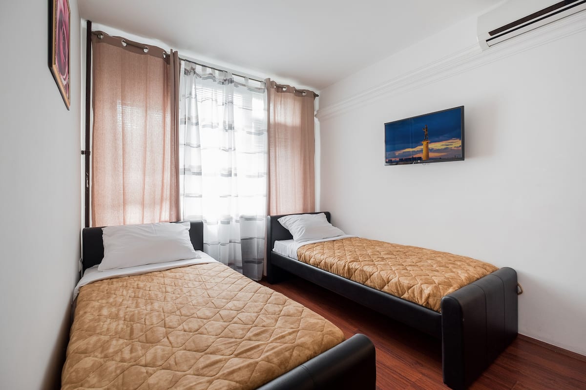 Comfort vierpersoonskamer, uitzicht op park | Een kluis op de kamer, een bureau, een strijkplank/strijkijzer