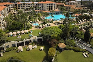 Un complexe hôtelier doté de plusieurs piscines, de chaises longues et de palmiers.