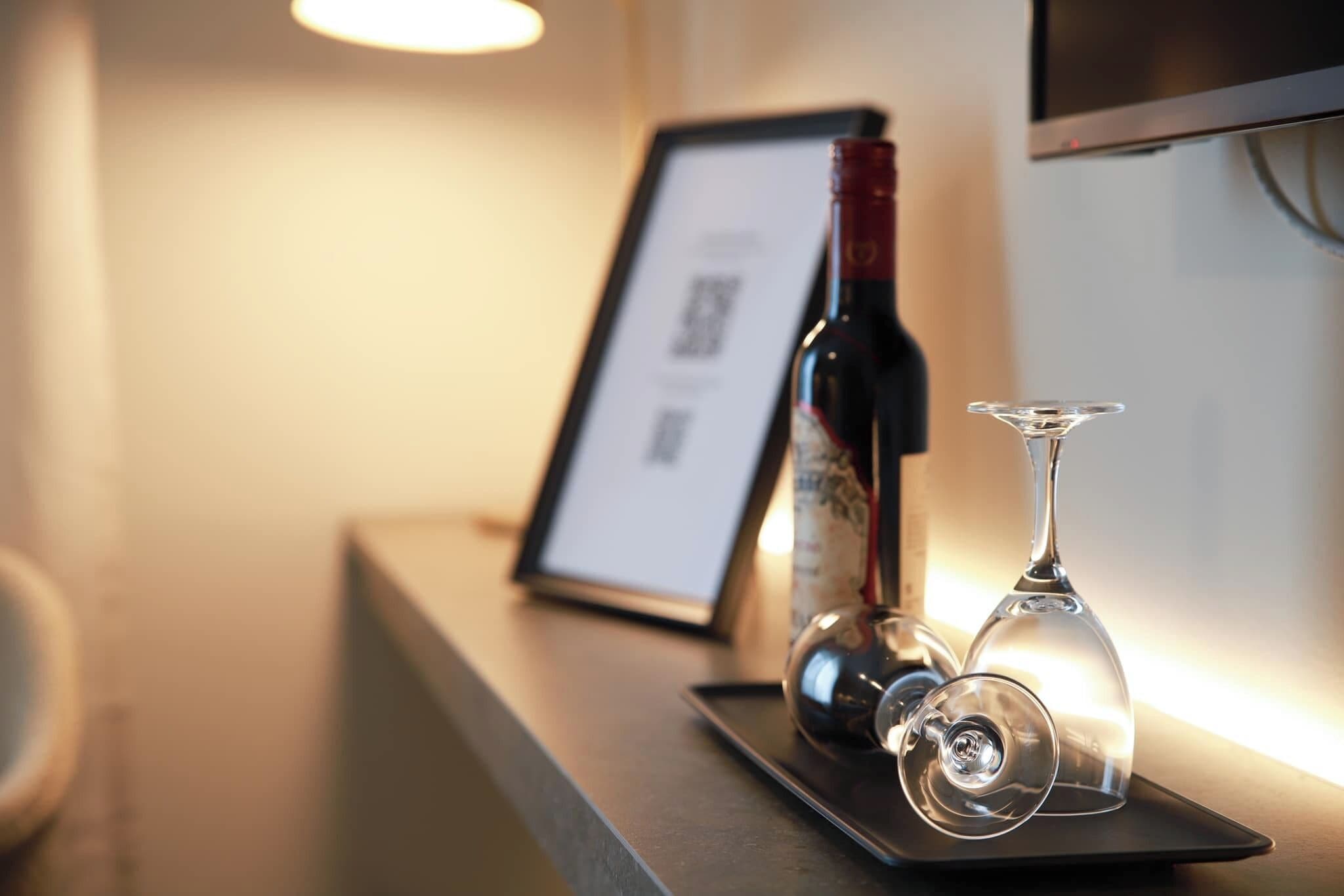 Een fles wijn en twee wijnglazen op een dienblad in een hotel.