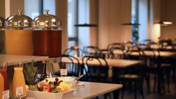 A breakfast buffet area with various food items and beverages.