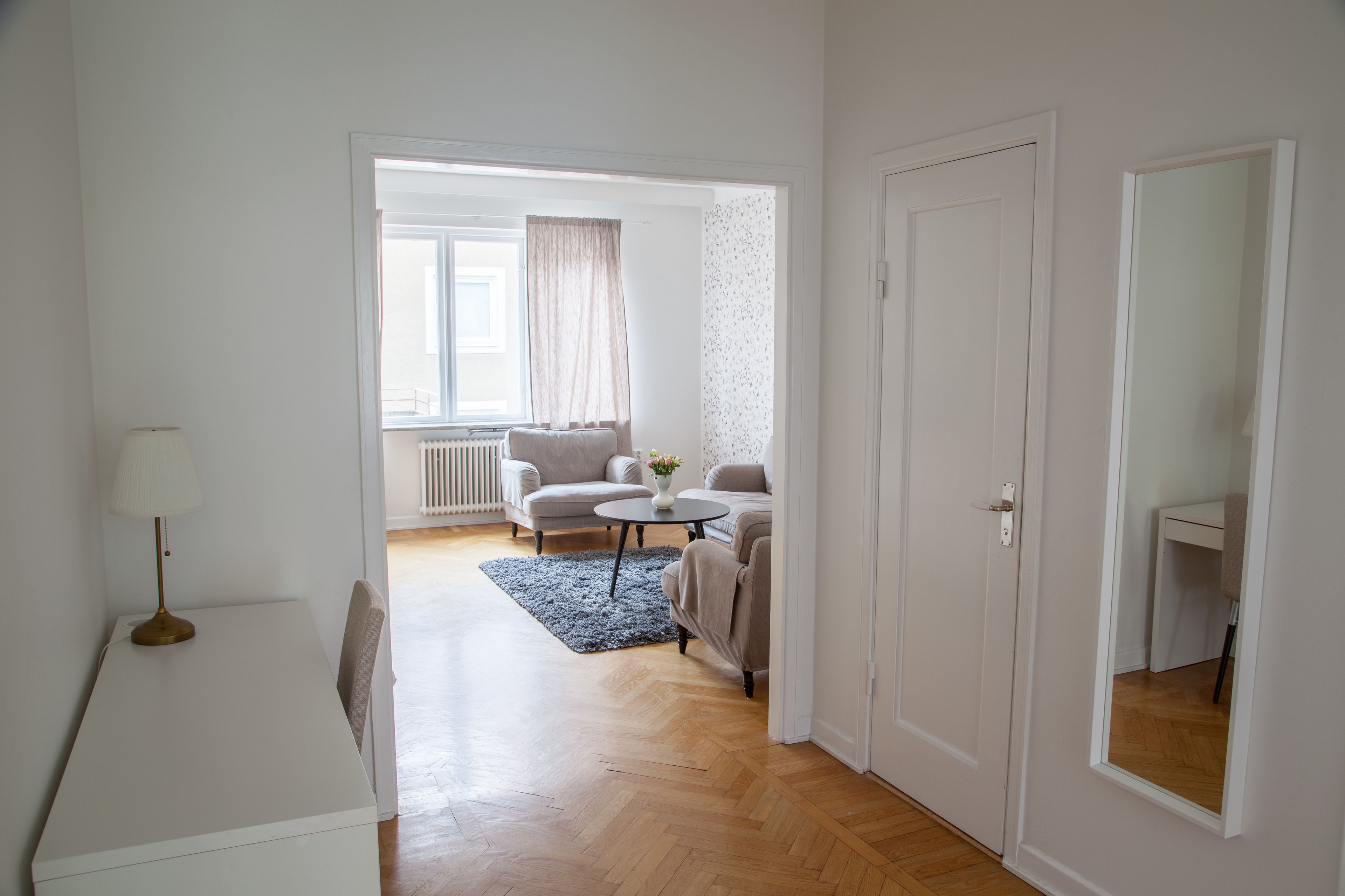 Un salon moderne avec un ensemble de canapés, une petite table ronde et une lampe.