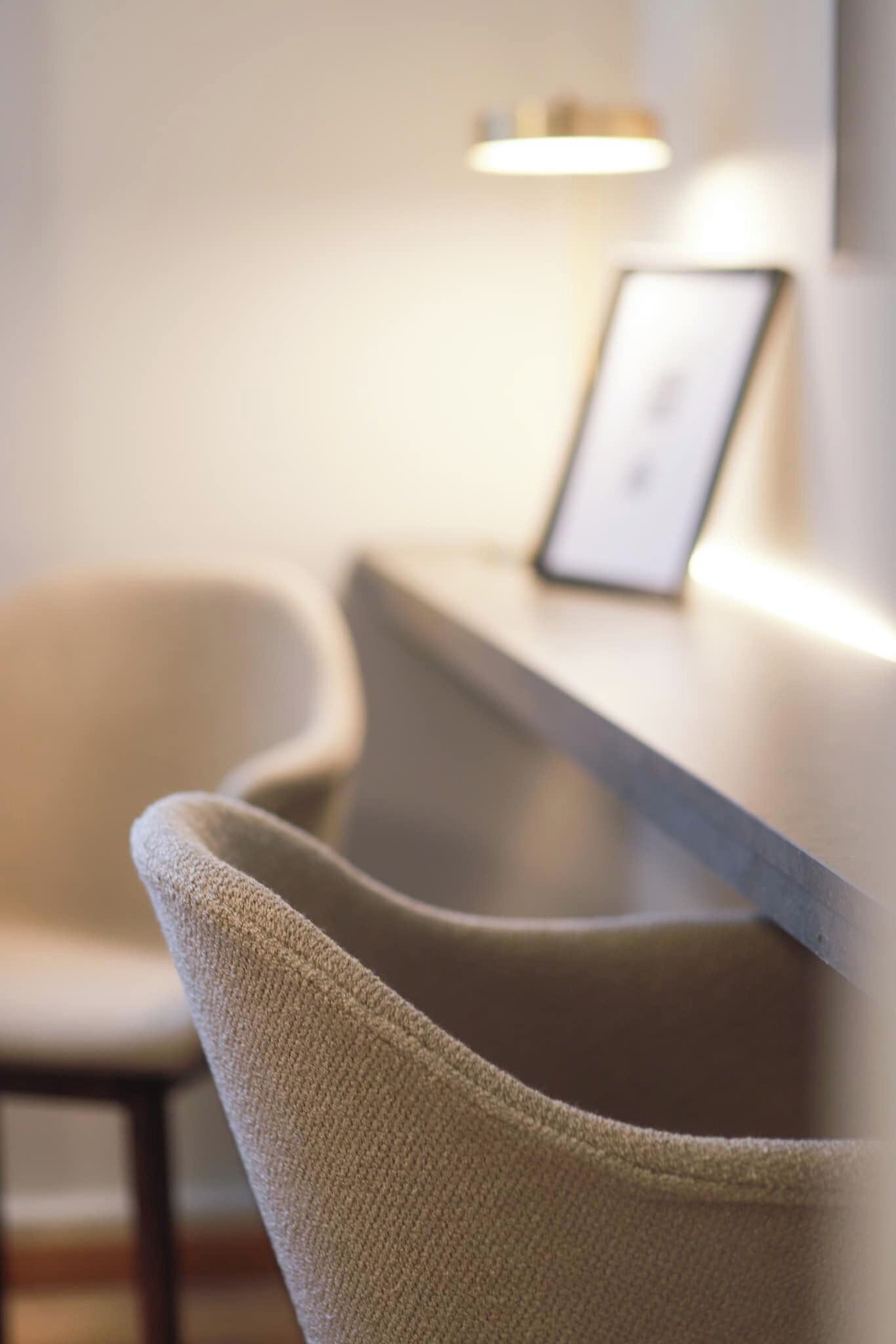 A reception desk with a framed picture and a chair.