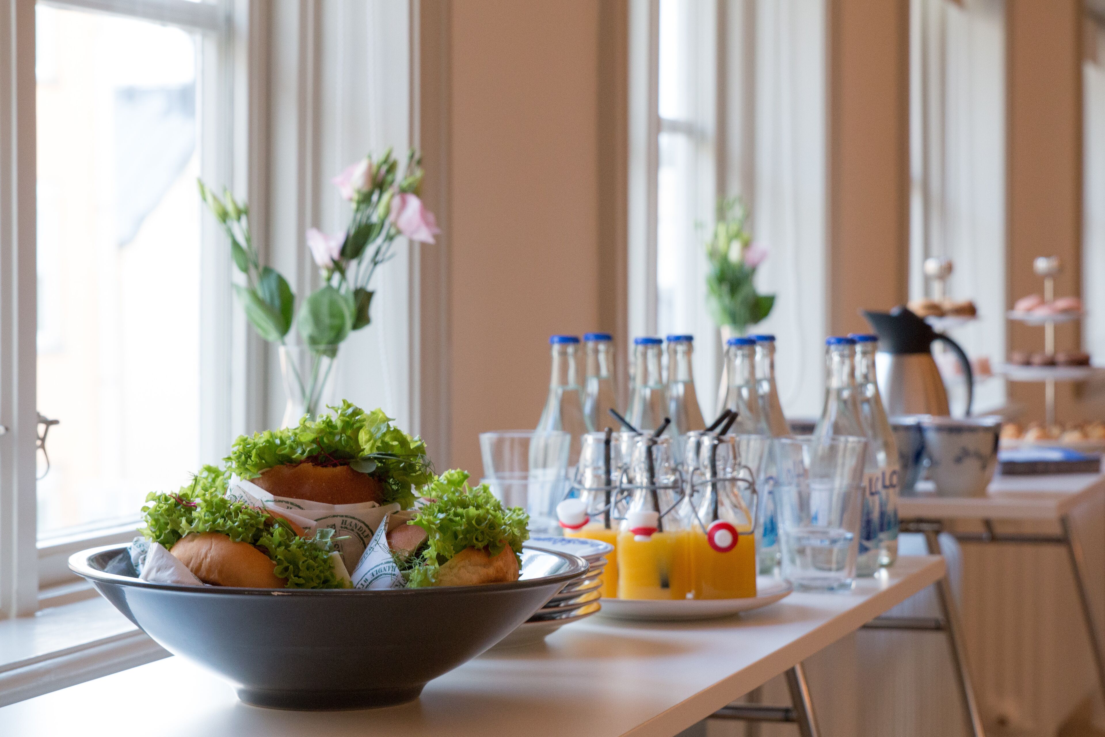 A table with a bowl of food, bottles, and glasses.