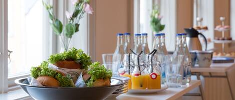 A table with a bowl of food, bottles, and glasses.