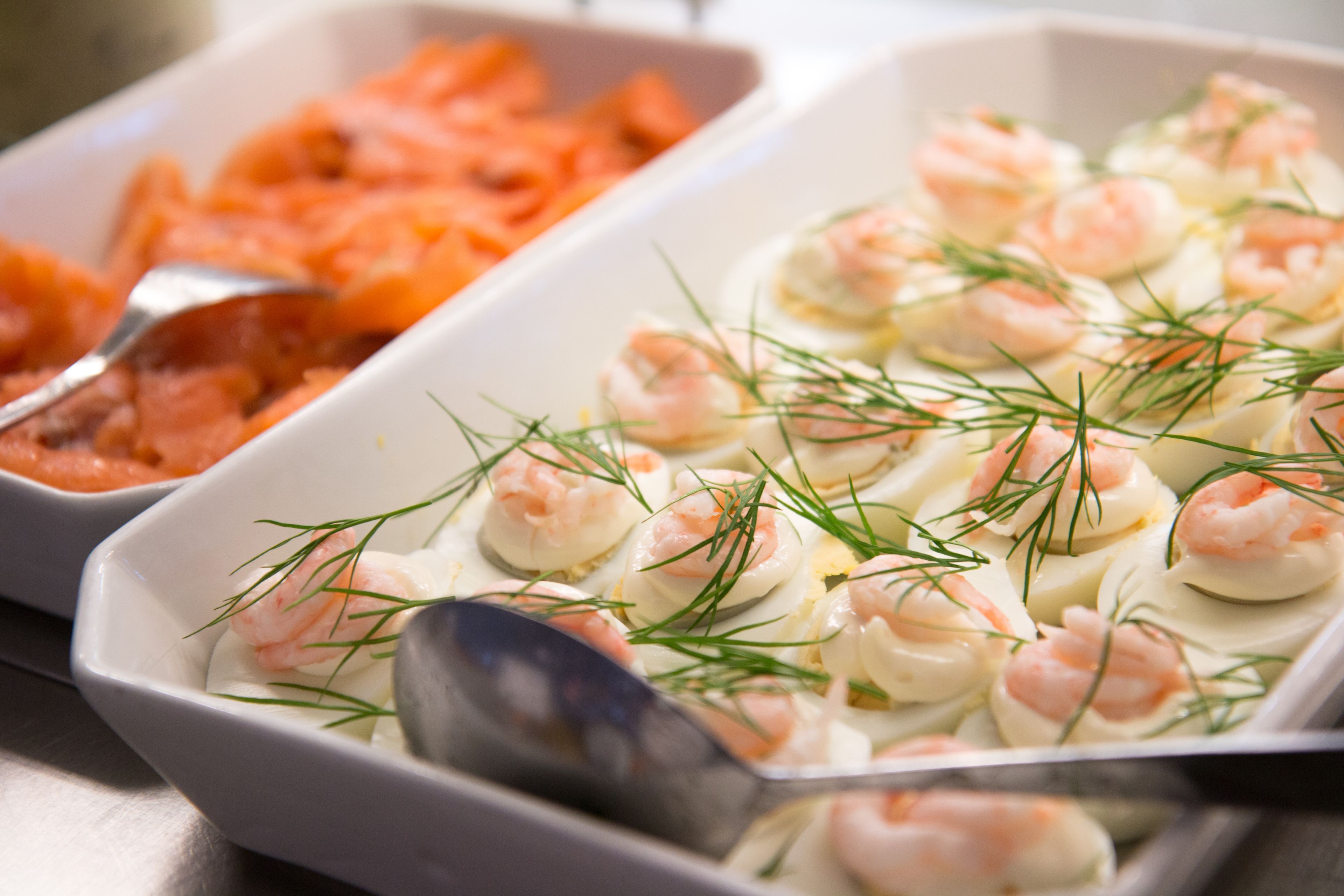 A buffet with shrimp and salmon dishes.