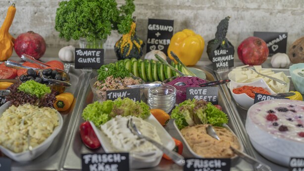 A buffet with various food options labeled in German, including fresh vegetables, salads, and dips. - BIG MAMA Berlin (Berlin)