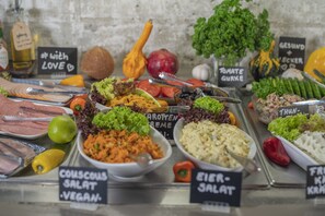 A variety of food items displayed on a counter with labels indicating different types of salads and dishes. - BIG MAMA Berlin (Berlin)