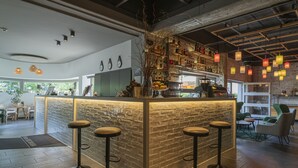 A modern bar area with a brick counter, bar stools, and hanging lanterns. - BIG MAMA Berlin (Berlin)