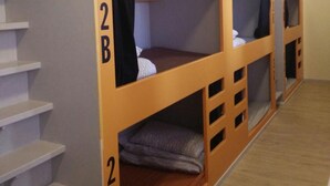 A room with bunk beds labeled 2A, 2B, and 2C, wooden flooring, and a staircase. - Birmingham Central Backpackers - Hostel (Birmingham)